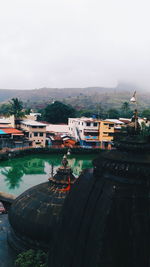 High angle view of buildings by lake against sky