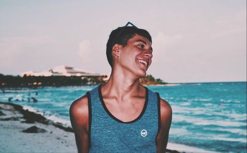 Mid adult man standing at beach against sky