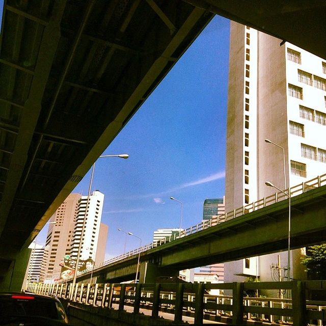 architecture, built structure, building exterior, low angle view, city, bridge - man made structure, sky, connection, transportation, modern, building, engineering, bridge, glass - material, office building, railing, no people, outdoors, city life, skyscraper