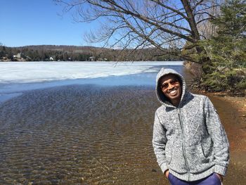 Portrait of smiling man standing by lake