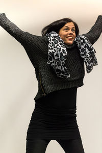 Portrait of smiling young woman against white background