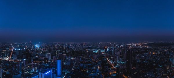 High angle view of illuminated city against sky at night