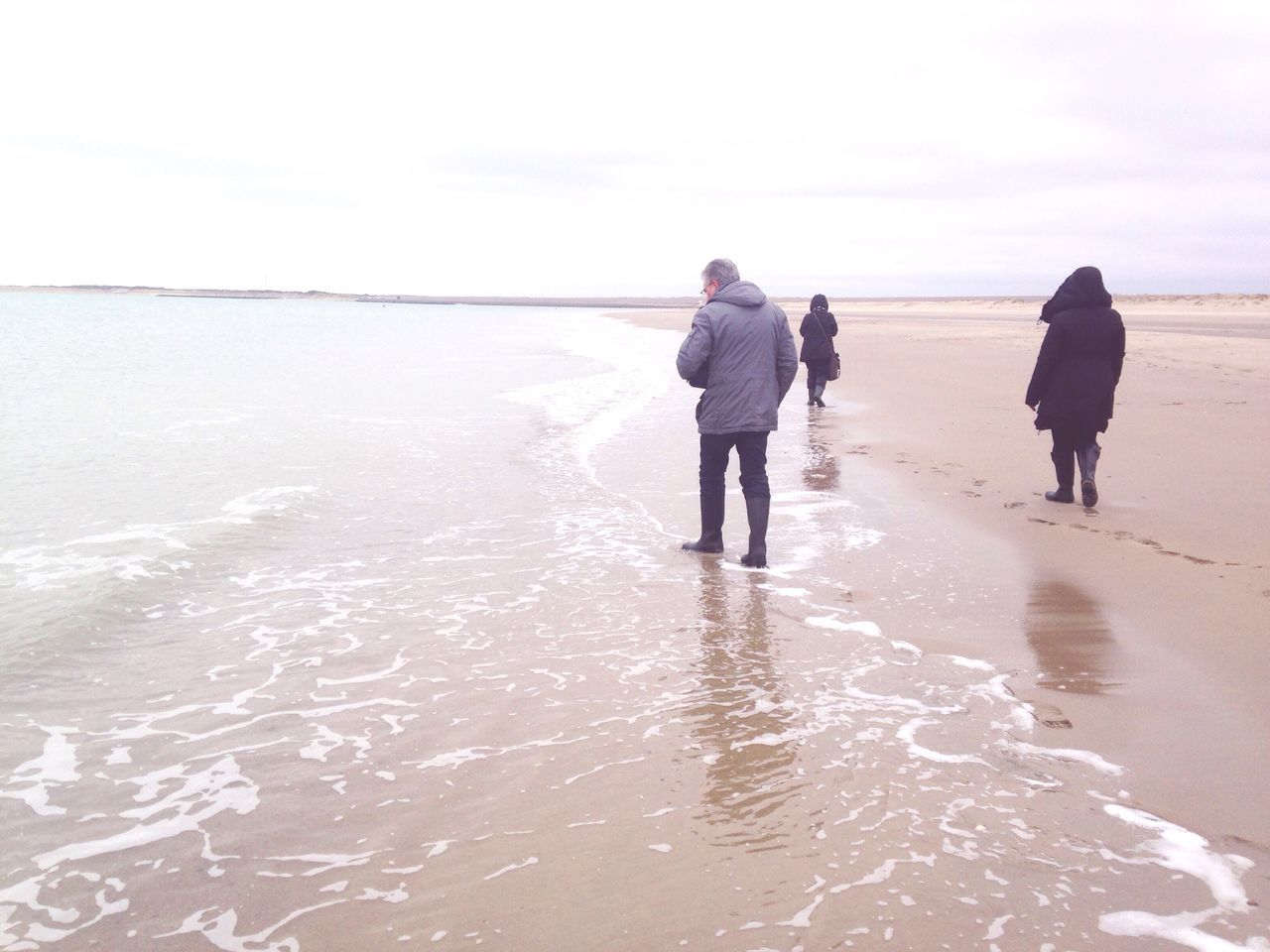 beach, water, sea, walking, shore, full length, sand, lifestyles, leisure activity, horizon over water, rear view, standing, wet, wave, vacations, sky, men, tranquil scene