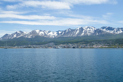 Scenic view of sea and snowcapped mountains against sky