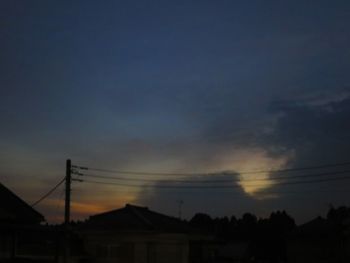 Low angle view of silhouette electricity pylon against sky at sunset