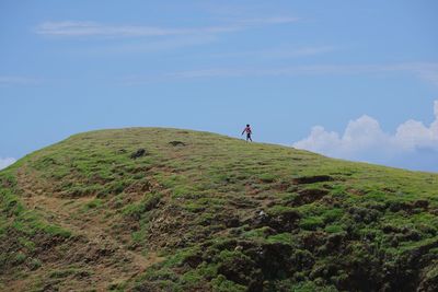 Man standing on cliff against sky