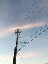 Low angle view of electricity pylon against sky