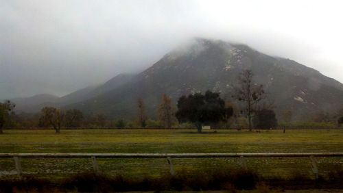 Scenic view of field and mountains against sky