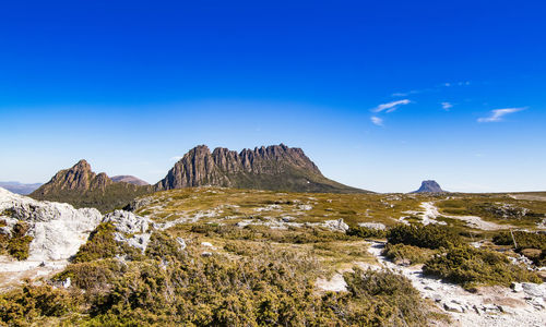 Scenic view of mountains against blue sky