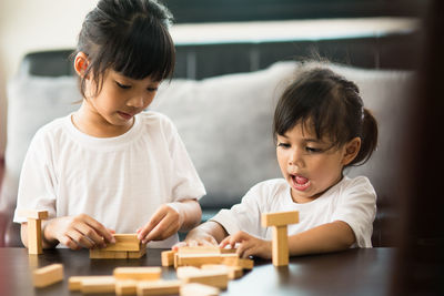 Cute girls playing with toy on table