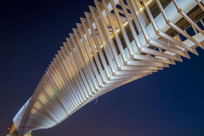 Low angle view of illuminated skyscraper against clear sky at night