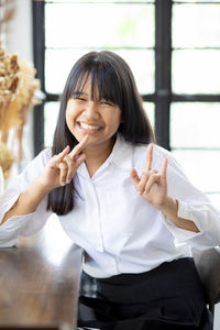 Smiling teenage girl gesturing while sitting in cafe