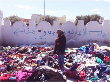 Woman standing amidst clothes