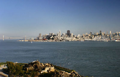 City at waterfront against clear sky