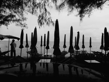 Wooden posts on beach against sky