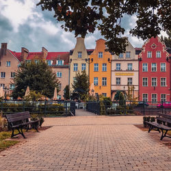 Footpath by buildings against sky in city