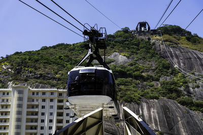 Low angle view of overhead cable car against sky