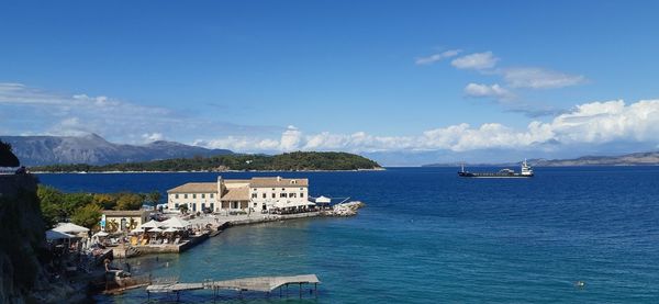 Scenic view of sea by buildings against sky