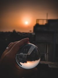 Close-up of hand holding glass during sunset