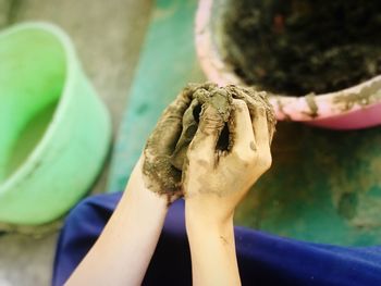 Close-up of hand molding a shape with mud