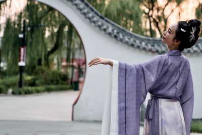 Portrait of young woman standing on road