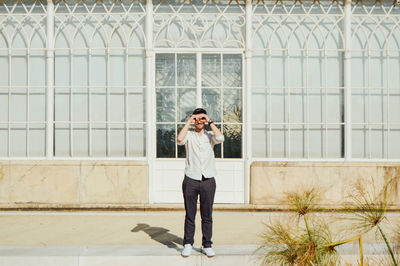 Full length of man gesturing while standing on floor