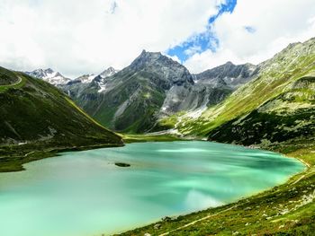 Scenic view of lake by mountains against sky