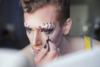 Young man applying drag makeup