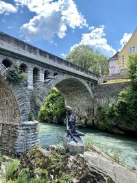 Arch bridge over river against sky