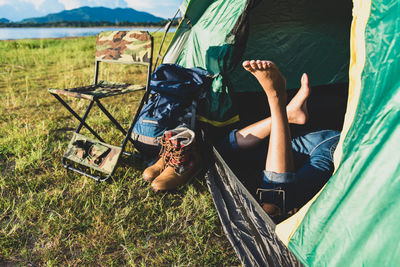 Low section of woman relaxing in tent