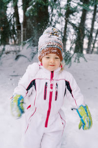 Portrait of smiling young woman standing in snow
