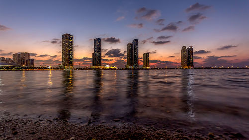 View of city at waterfront during sunset