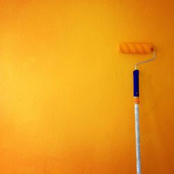 Paint roller on yellow wall