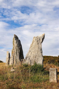 Rock on field against sky