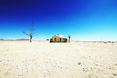 Built structure on beach against clear blue sky