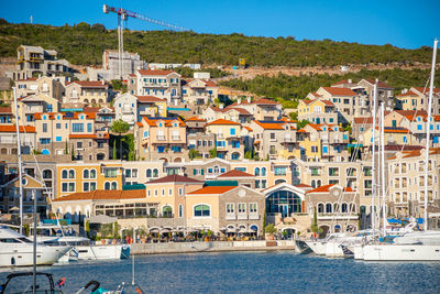 Houses by sea against sky in city