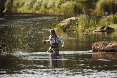 Woman fishing in lake