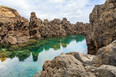 Rock formation in a pool against the sky 