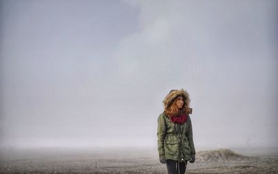 Young woman standing by railing