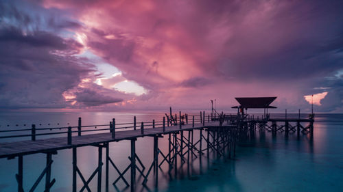 Pier over sea against sky during sunset