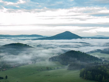 Scenic view of mountains valley with autumn fall against dark sky