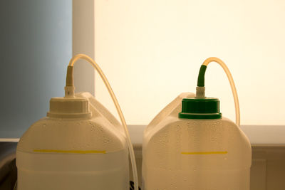 Close-up of yellow bottle against white wall