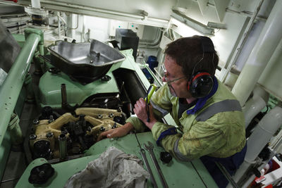 High angle view of manual worker working at workshop