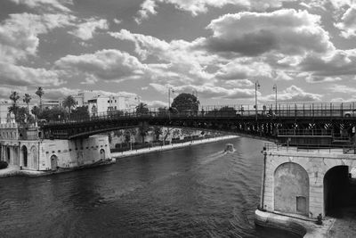 Bridge over river against buildings in city