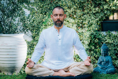 Meditating man. peaceful man sitting in a lotus position and meditating in the garden.
