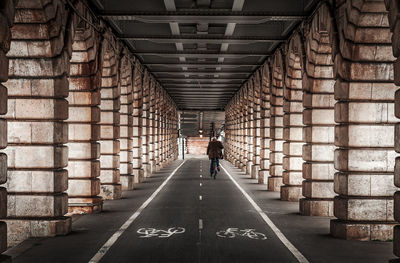 Rear view of man walking in corridor