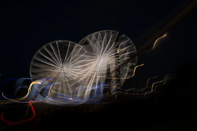 Low angle view of illuminated lights against sky at night