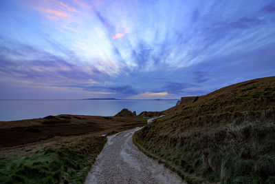 Road leading towards sea against sky