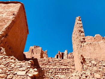 Low angle view of old ruin building against blue sky