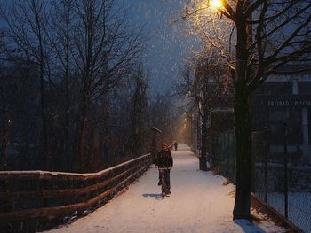 Silhouette woman on snow covered trees against sky